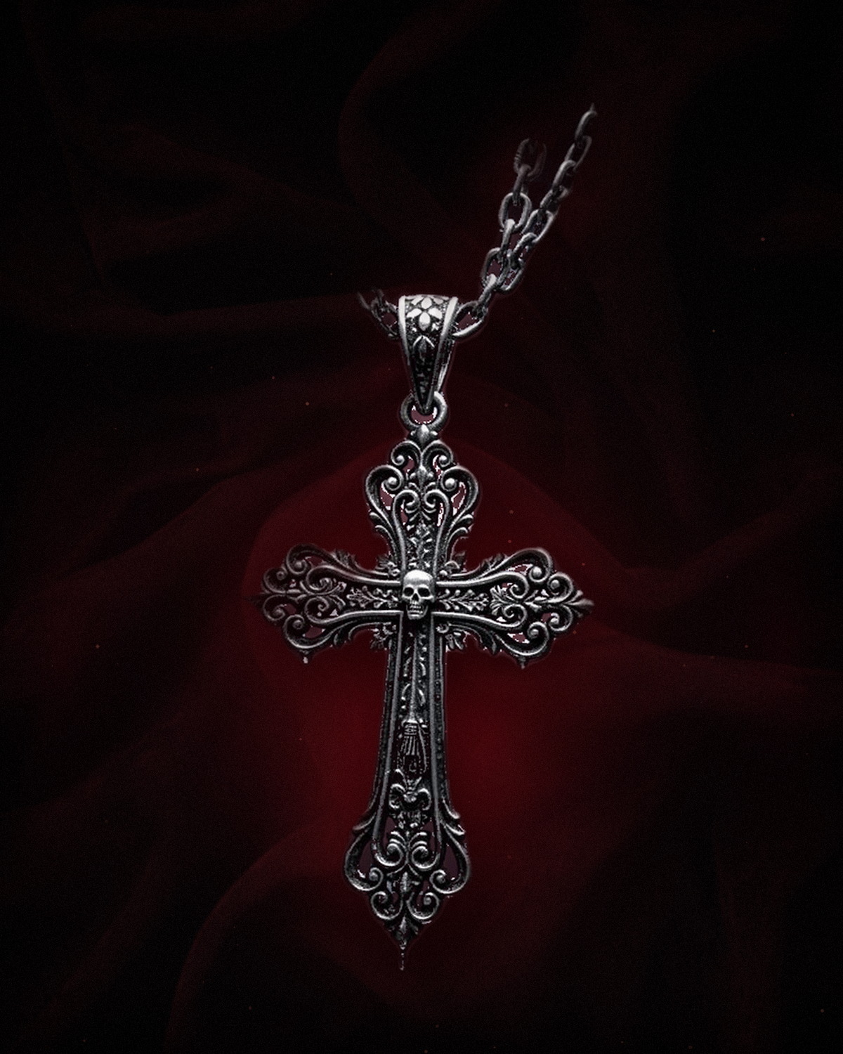 The Requiem Cross — a hand-finished silver gothic cross necklace with a lab-grown ruby on black velvet